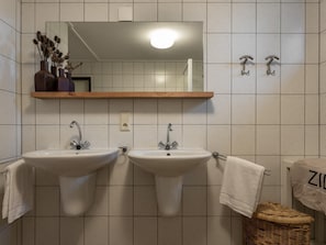 A bathroom with two sinks, a mirror, and a towel rack. - Family villa near Lake Veere with garden (Kamperland)