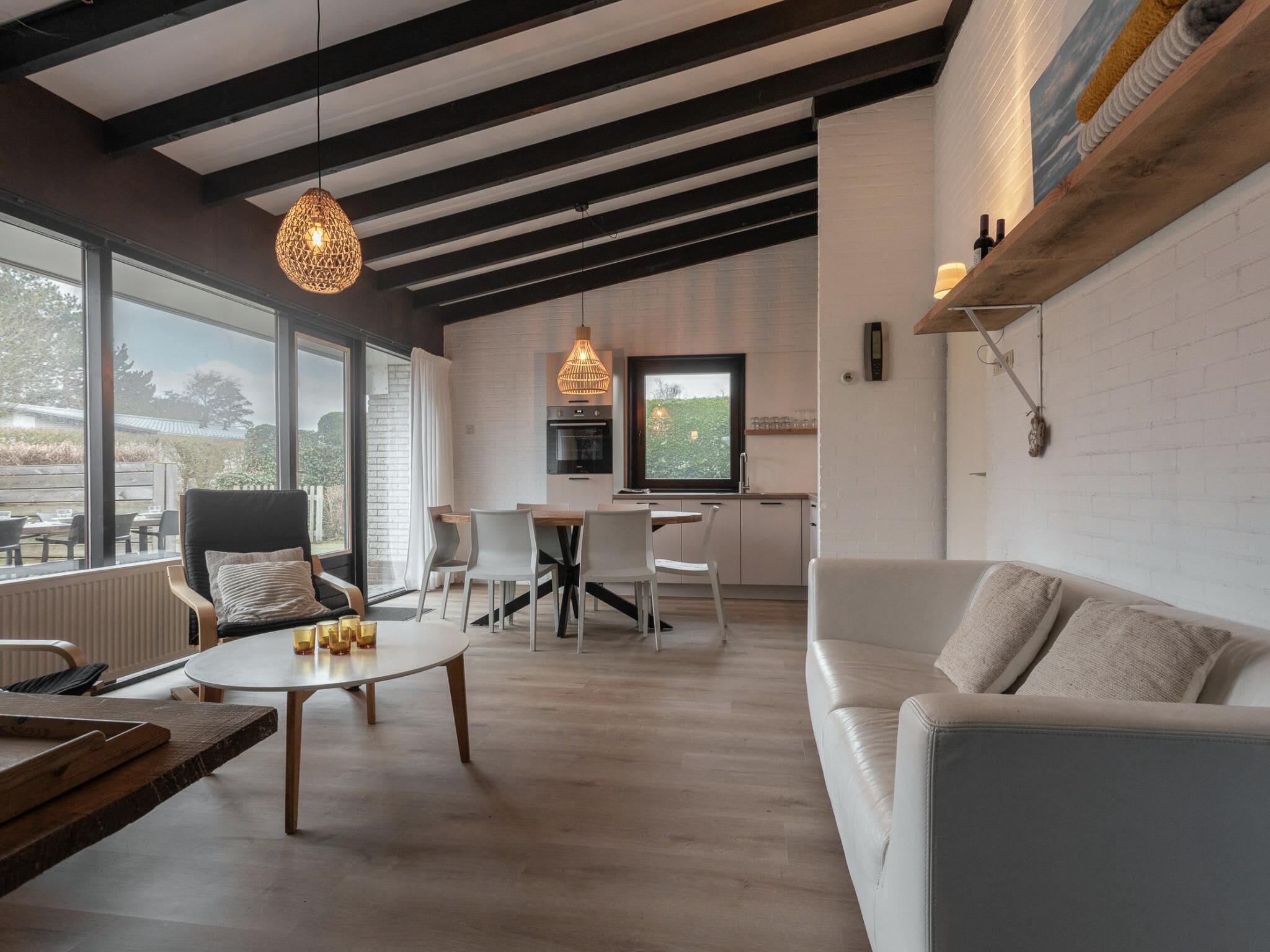 A modern interior with a dining area, a sofa, and a kitchen.