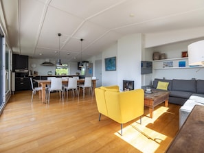 A modern living room with a yellow armchair, a grey sofa, and a wooden coffee table. - Spaciously designed home by Veerse Meer. (Kamperland)