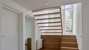 Una escalera con escalones de madera y una pared blanca.