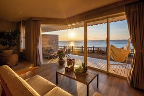 A spacious balcony with a view of the sea, a hammock, and a seating area with a table and plants. - Komatsushima Resort (Tokushima)