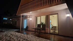 A house with a covered patio, a table, chairs, and a laptop. - Family-friendly with garden & private parking lot Suitable for fitters & groups (Oldenburg (Oldb))