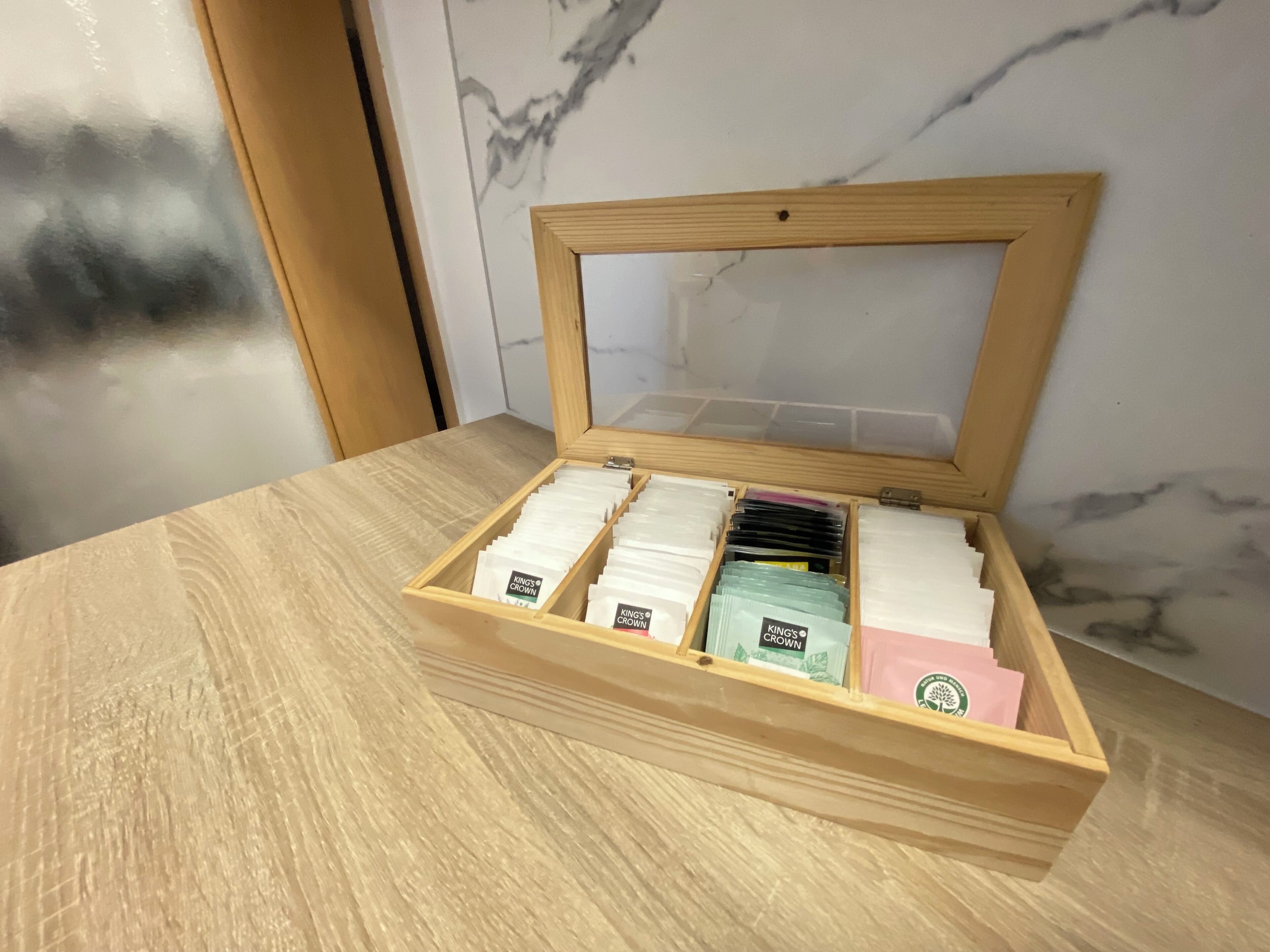 Une boîte en bois dotée de compartiments contenant divers objets.