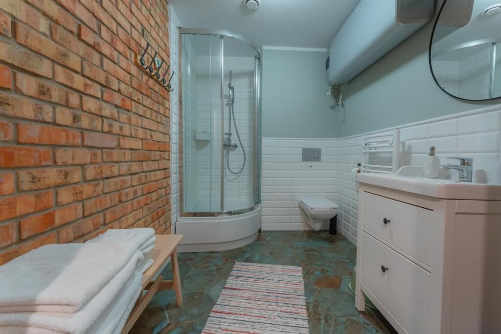 A bathroom with a shower, toilet, and sink.