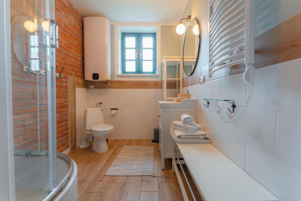 A bathroom with a toilet, sink, and shower.