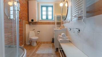 A bathroom with a toilet, sink, and shower.