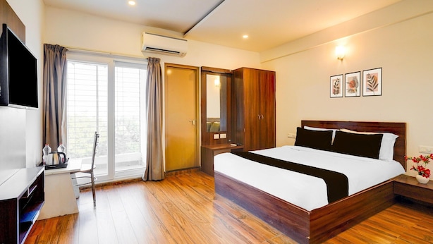Une chambre d’hôtel avec un lit, un bureau, une armoire et un téléviseur.