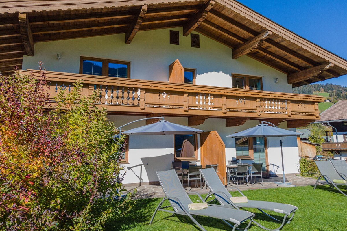 Ein Chalet mit Balkon, Sitzgelegenheit im Freien und Garten.