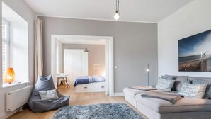 A modern living room with a sofa, a rug, and a painting on the wall.