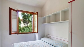A bedroom with a bed, a window, and a wardrobe. - Apartment in San Teodoro (San Teodoro)