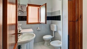 A bathroom with a toilet, bidet, and sink. - Apartment in San Teodoro (San Teodoro)