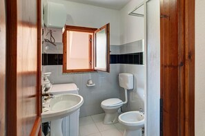 A bathroom with a toilet, bidet, and sink. - Apartment in San Teodoro (San Teodoro)