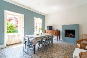 A dining area with a table and chairs, a fireplace, and a television. - Appartamento in Centro Storico a Cannero Riviera (Cannero Riviera)