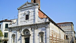 A historic building with classical architecture, including a bell tower and ornate facade. - Lucca Central Garden Cottage (Lucca)