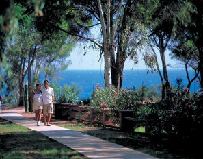 A pathway with benches, trees, and a view of the sea. - Apartments in Pula With Shared Saltwater Pool (Pula)