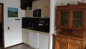 A compact kitchen with a microwave, dishwasher, and wooden cabinets. - Apartment With Parking for 6 People (Chatel)