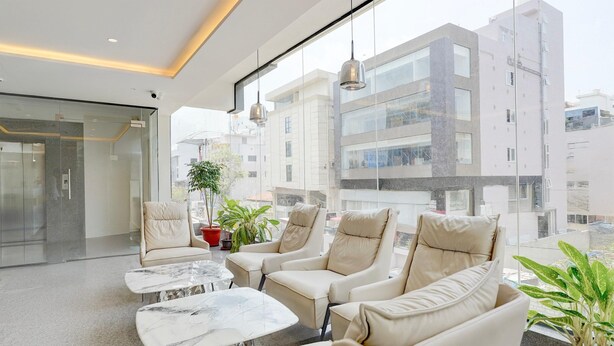 Ein modernes Interieur mit einer Sitzecke, Glaswänden und Blick auf die Stadt.