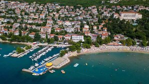 An aerial view of a coastal town with a marina, beach, and residential buildings. - Holiday apartment with air conditioning (Crikvenica)