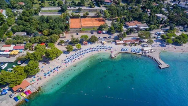 An aerial view of a coastal area with a beach, a pier, and several buildings. - Holiday apartment with air conditioning (Crikvenica)