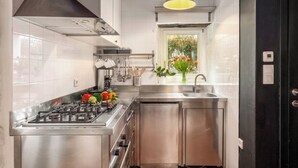 A modern kitchen with stainless steel appliances, a window with a view, and a pendant light. - Finca with pool and garden, pets welcome (Vižinada)