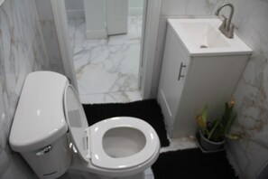 A bathroom with a toilet, sink, and a potted plant. - Wonderful studio with AC in charming Miramar (Miramar)