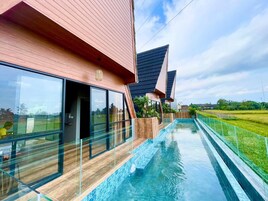 Una casa moderna con piscina, ventanas amplias y vistas del paisaje circundante.