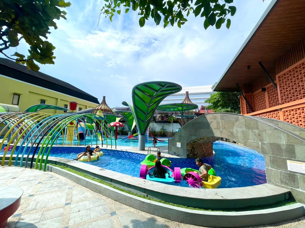 Zona de piscina con toboganes y juguetes inflables.