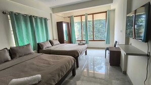 A hotel room with two beds, a desk, a chair, a TV, and large windows with curtains. - Ameya Coorg (Madikeri)