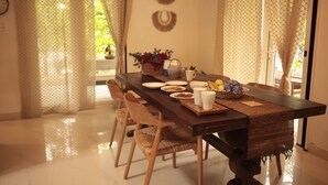 Zona pranzo con un tavolo lungo, sedie e un elemento decorativo al muro.