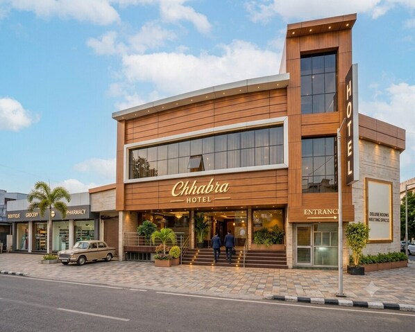 Un hôtel au design moderne, doté d’une entrée imposante, d’une enseigne et d’un escalier bien visible menant à l’entrée.