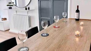 A dining table with candles, wine glasses, and a bottle.