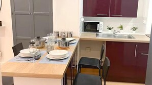 A compact kitchen with a microwave, sink, and dark cabinets.