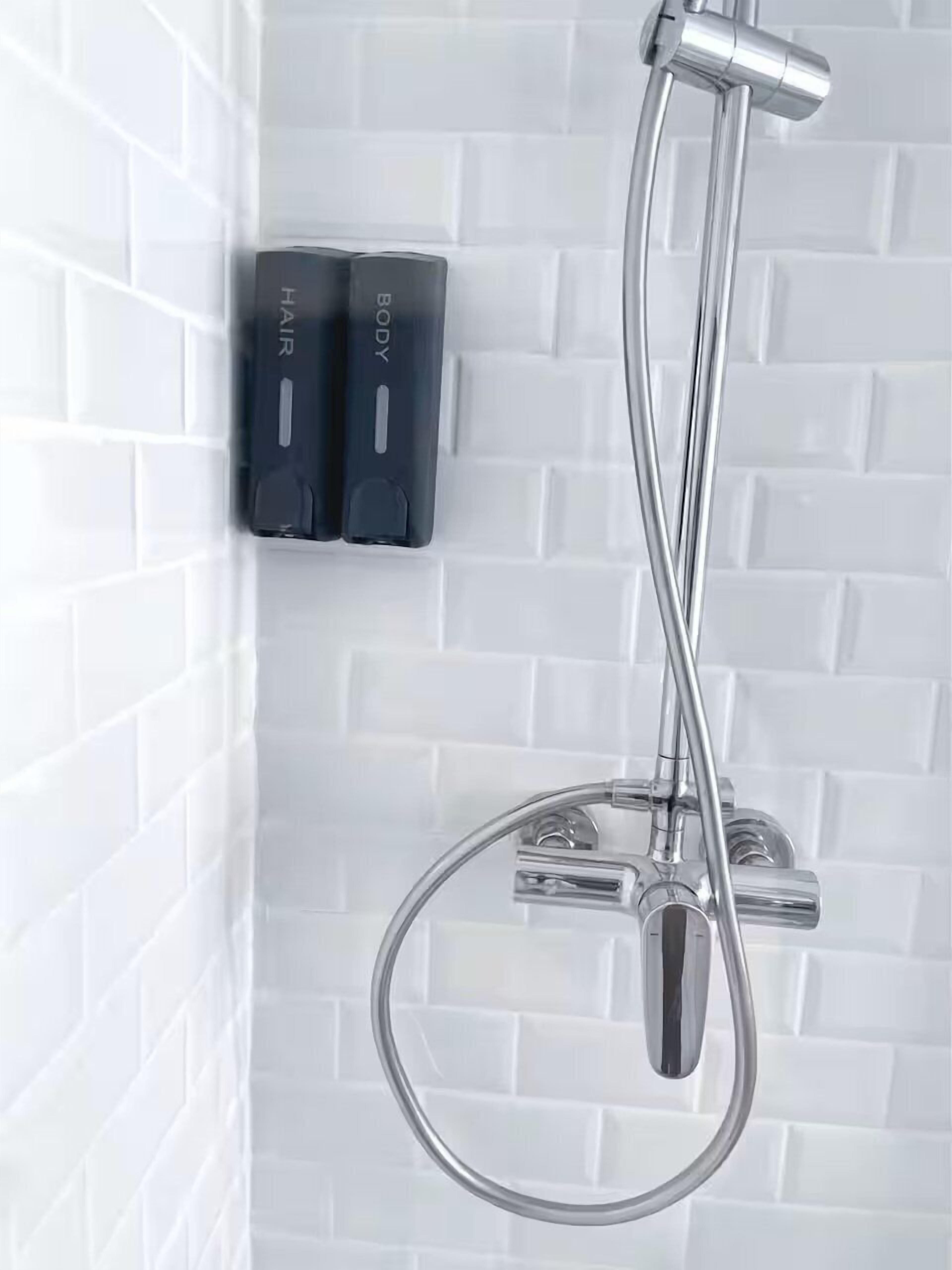 A shower with a chrome hose and two black control panels labeled 'HABIT' and 'BODY'.