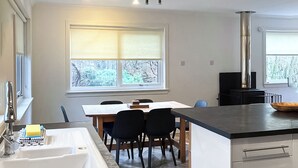 Une cuisine moderne équipée d’un évier, d’une table à manger, de chaises et d’une cuisinière.