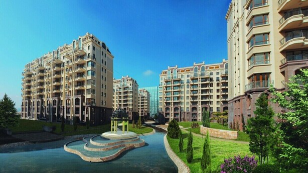 Un edificio residenziale a più piani con balconi, un cortile interno e un elemento decorativo a base d'acqua.