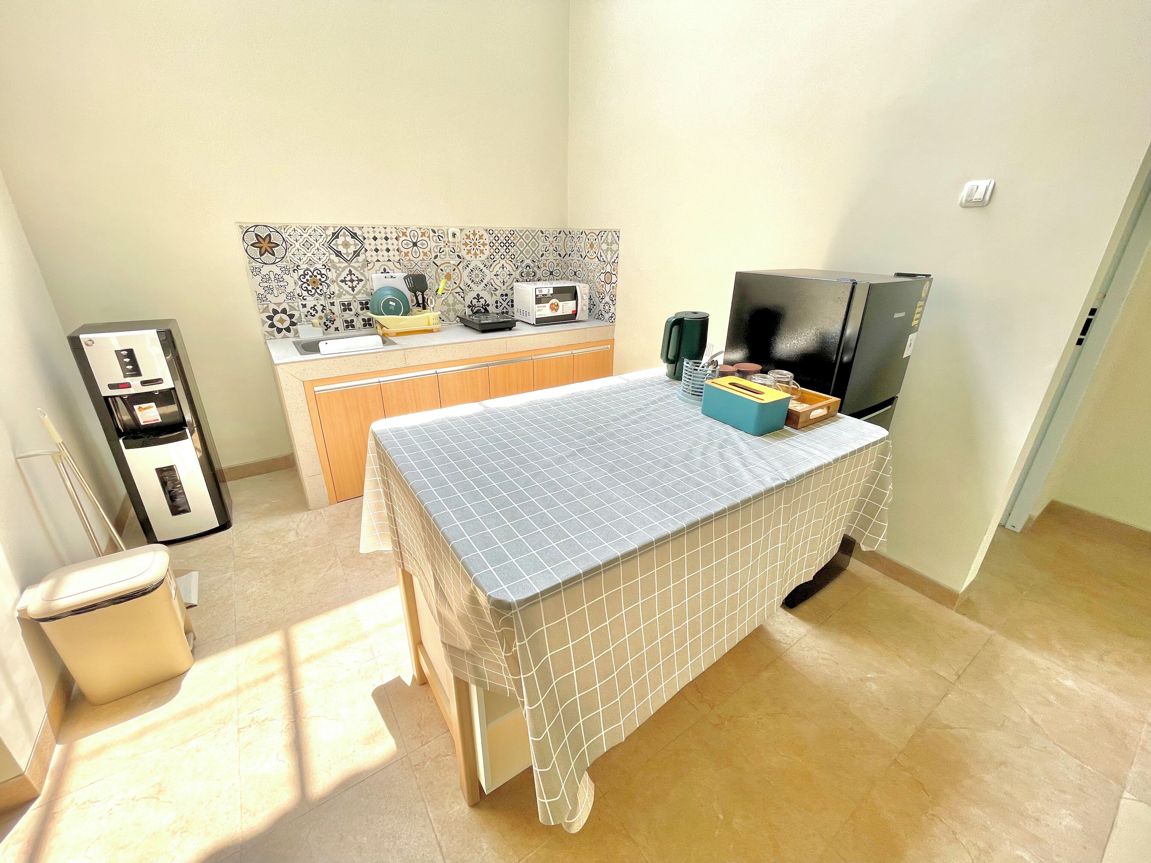 A compact kitchen with a refrigerator, microwave, and sink.