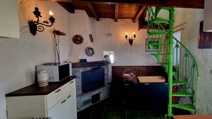 A kitchen with a microwave, a fireplace, and a green spiral staircase. - Chalet with garden and lake view (Lesa Massino Visconti)