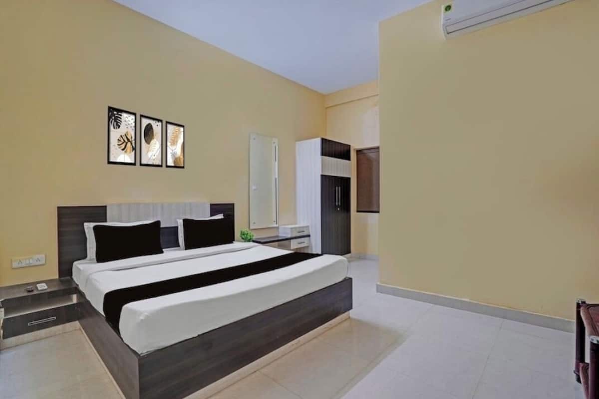 Un dormitorio moderno con una cama grande, una mesita de noche, un armario y un equipo de aire acondicionado de pared.