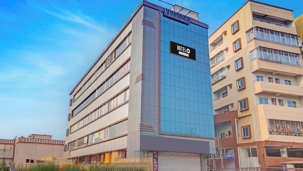 A modern hotel with a glass facade, a prominent 'HOTEL' sign, and a visible entrance. - Hotel Sri Krishna Palace (Bhubaneshwar)