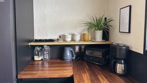 A kitchen with a wooden countertop, a coffee maker, a kettle, a toaster, and a potted plant. - Rusutsu Tsuru House 2. (喜茂別町)
