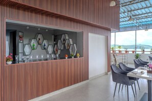 Ein modernes Interieur mit einer Holzwand, einer Glasvitrine mit Flaschen und Blick auf das Meer.