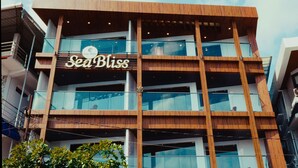A multi-story building with a wooden facade and large glass windows. - SEA BLISS (Port Blair)