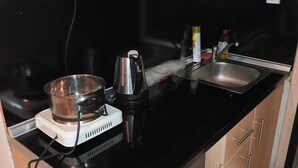 Et køkken med komfur, vask og bordplade.