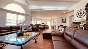 A spacious living room with leather sofas, a glass coffee table, and a dining area with a table and chairs. - La Habra Heights Luxury Escape with 7 bedroom (Hacienda Heights)