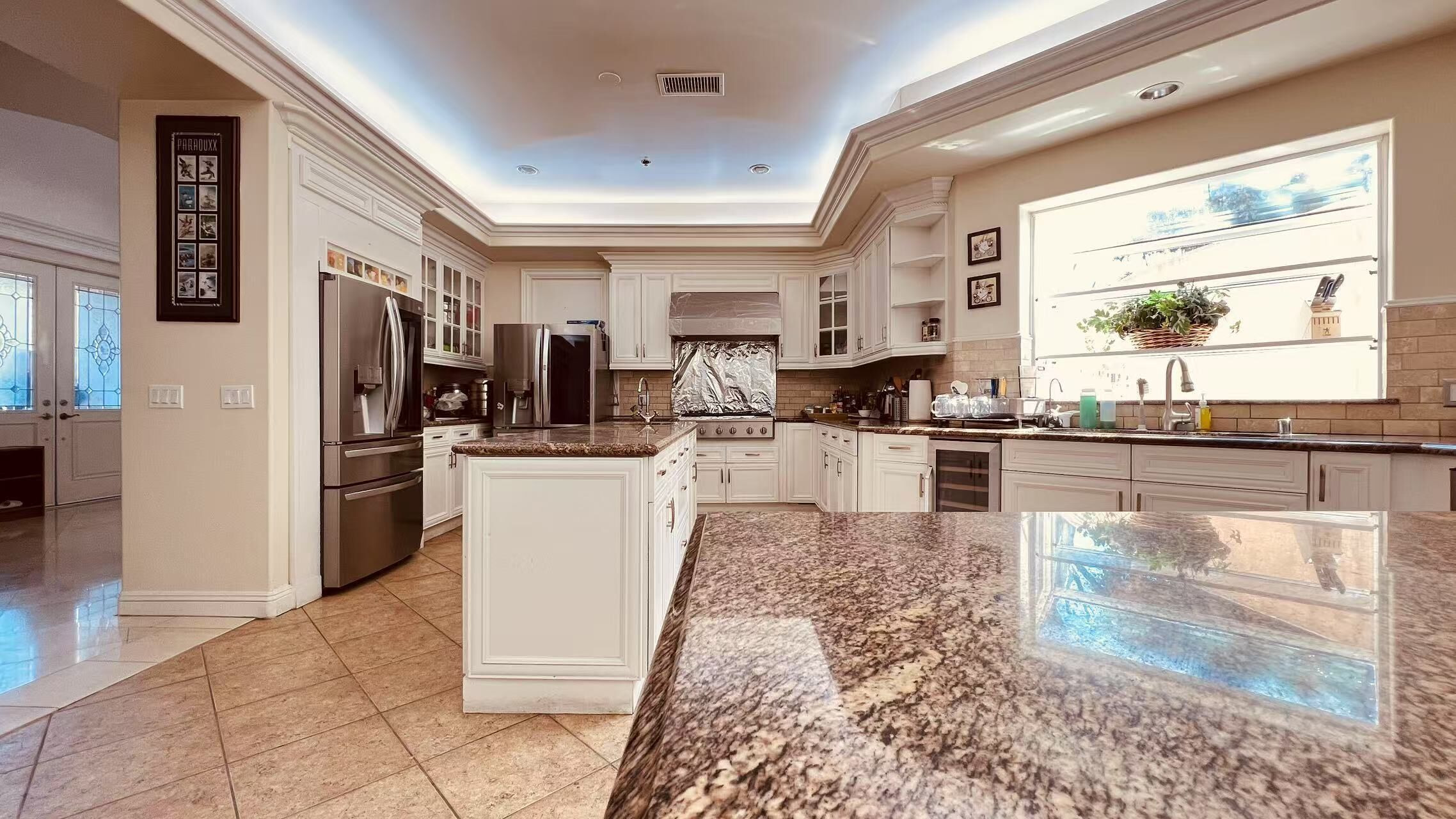 A spacious kitchen with granite countertops, stainless steel appliances, and a large island.