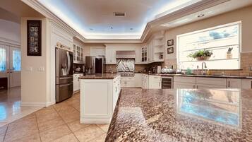 A spacious kitchen with granite countertops, stainless steel appliances, and a large island.