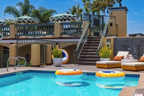 A pool area with lounge chairs, a lifeguard stand, and a sign warning against diving. - Rooftop Ocean Views + Pool + Hot Tub + Walk to Beach | The Mara by AvantStay (Laguna Beach)