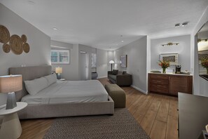 Una camera da letto moderna con un letto grande, comodini, un divano e un angolo studio.