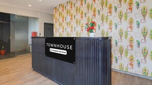 Mostrador de recepción con un cartel que dice 'Townhouse Company-Serviced'.