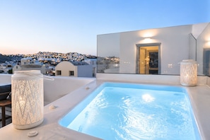 Une piscine sur le toit offrant une vue sur le paysage urbain au crépuscule.
